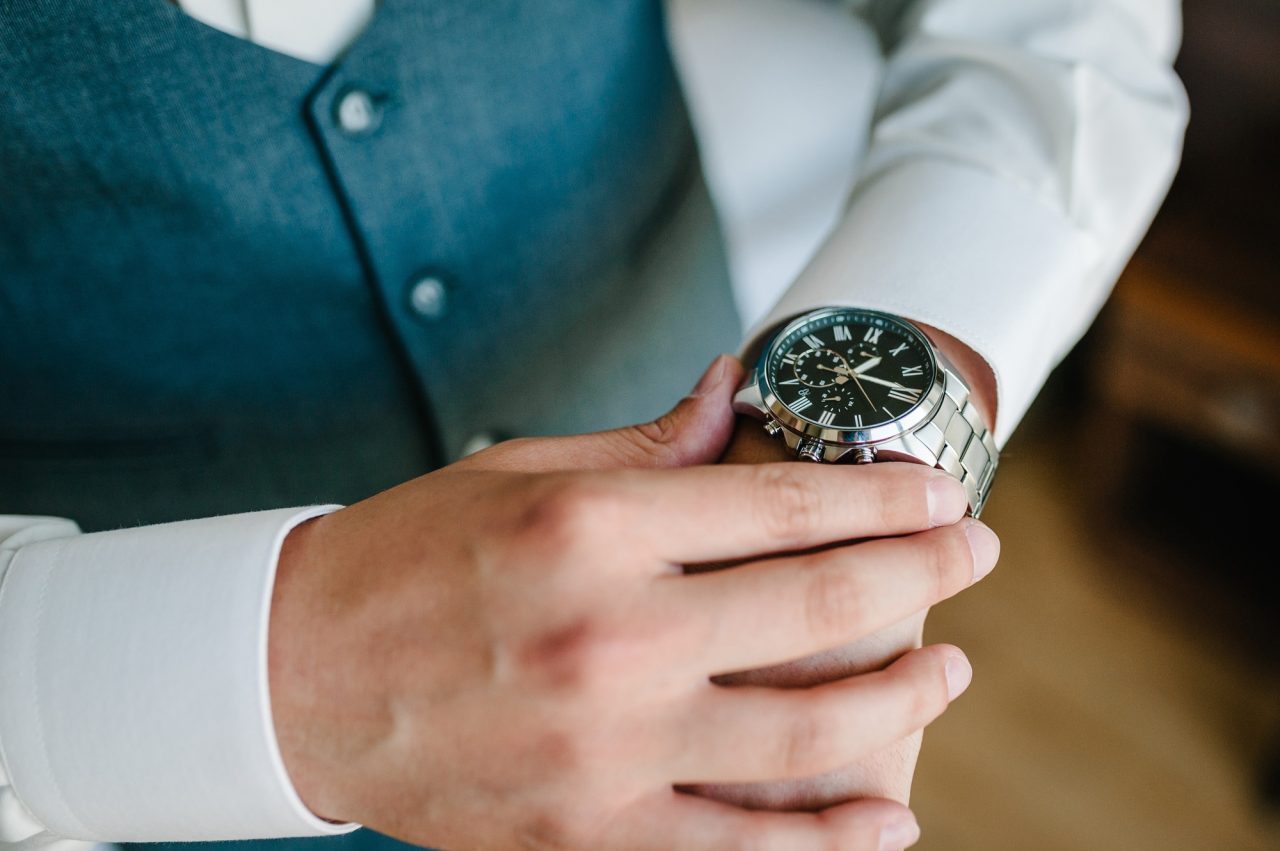 a man in a shirt adjusts the watch on his arm close up of businessman using watch .jpg